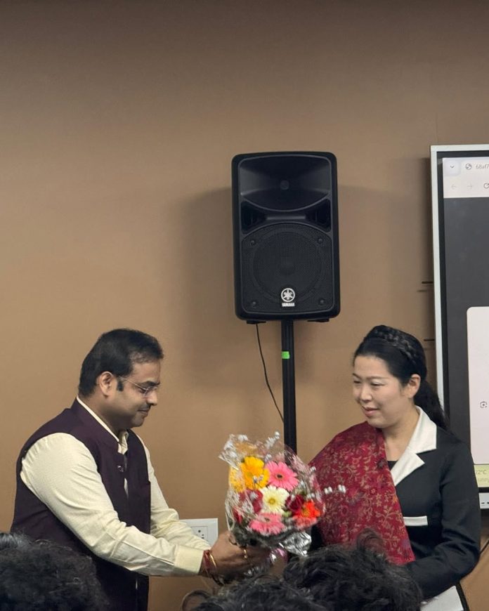 Dr. Vikas Bharadwaj presents a shawl and bouquet to Dr. Chaerin Kim during her guest lecture at NMIMS SoPA.